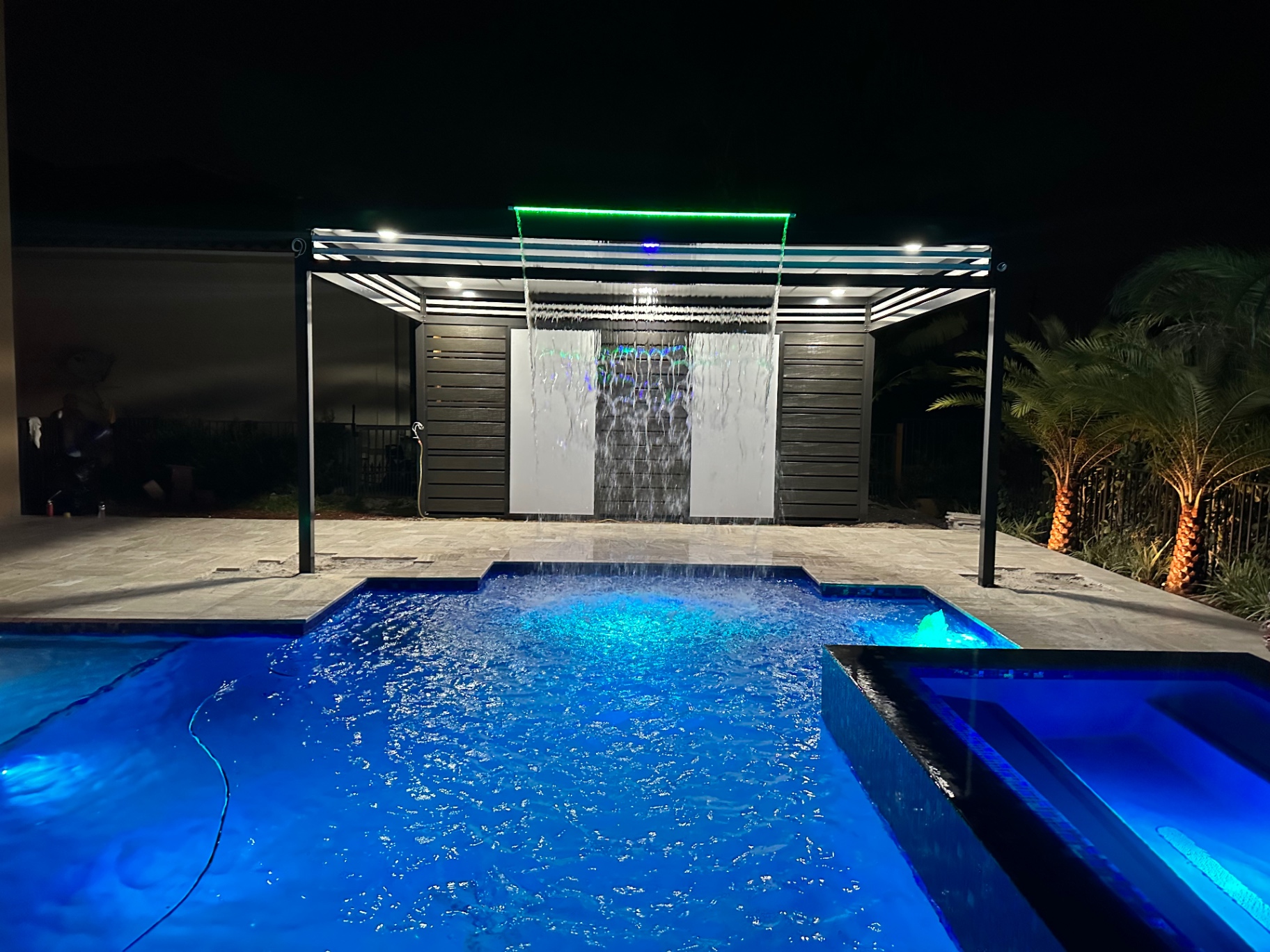 Luxury Florida waterfront home with aluminum pergola at neon sunset